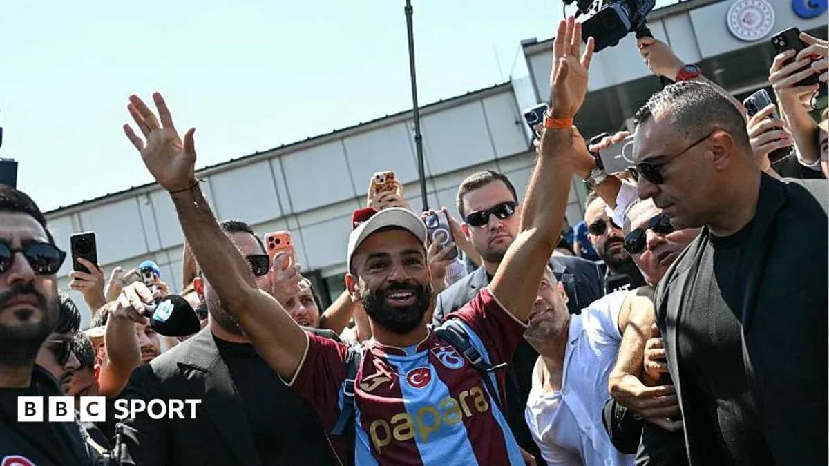 Futbolchi muxlislar orasida qo'lini ko'tarib turibdi Futbolchi muxlislar orasida qo'lini ko'tarib turibdi