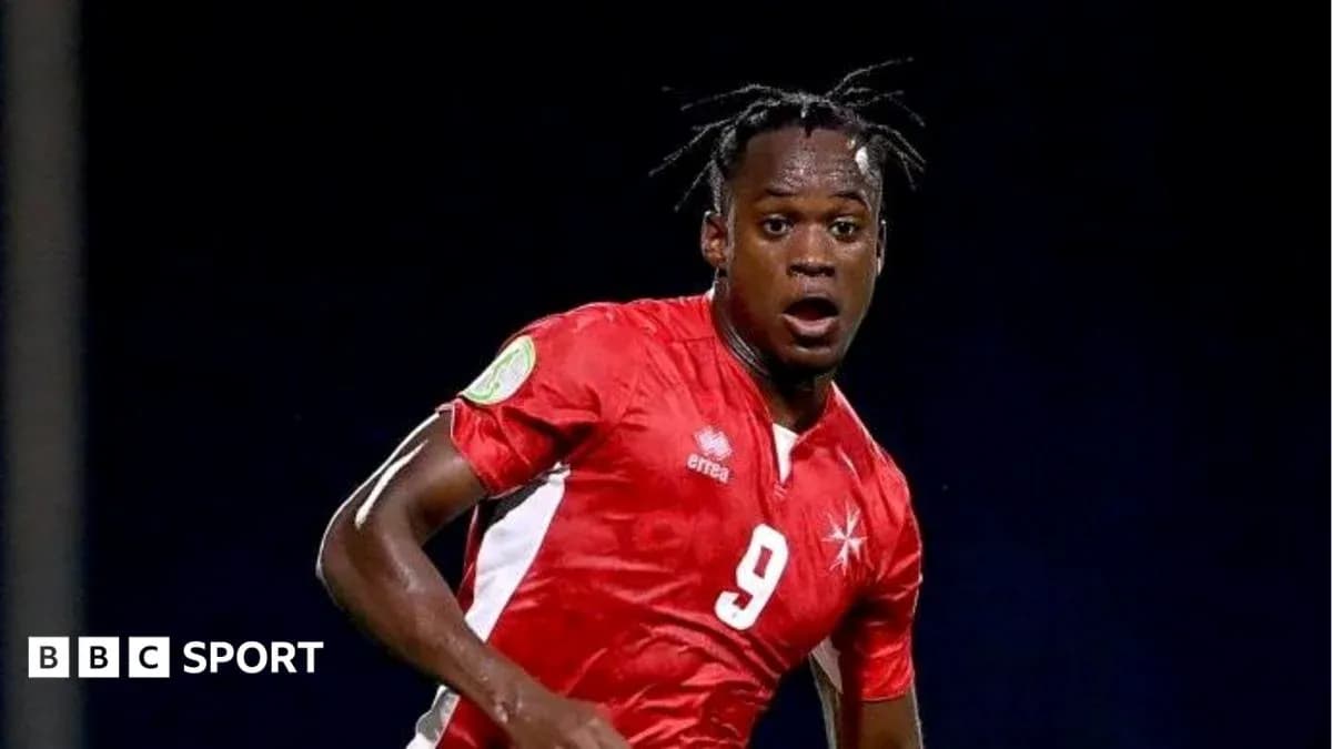 Futbolchi raqibga qarshi harakatda, qizil forma kiygan Futbolchi raqibga qarshi harakatda, qizil forma kiygan