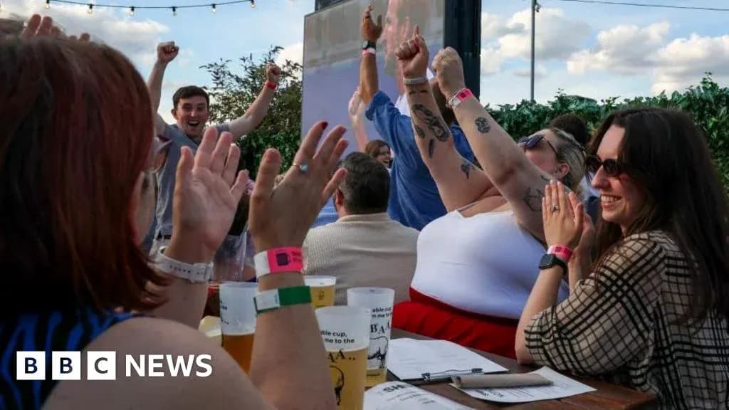 People celebrating with raised hands at outdoor event People celebrating with raised hands at outdoor event