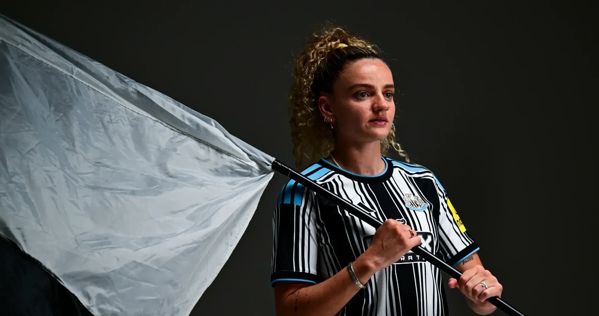 Ayol futbolchi bayroq bilan poz berayotgan Ayol futbolchi bayroq bilan poz berayotgan