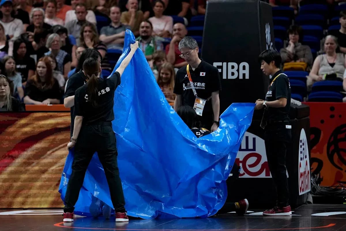 Staff covering the court with a blue tarp Staff covering the court with a blue tarp