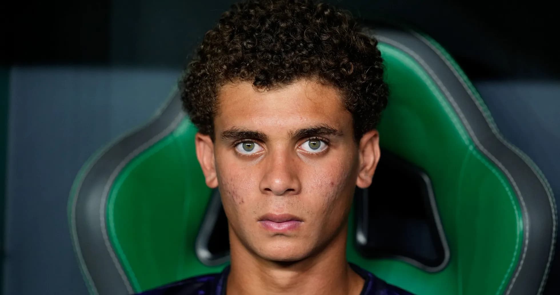 Young player seated in sports chair, serious expression Young player seated in sports chair, serious expression