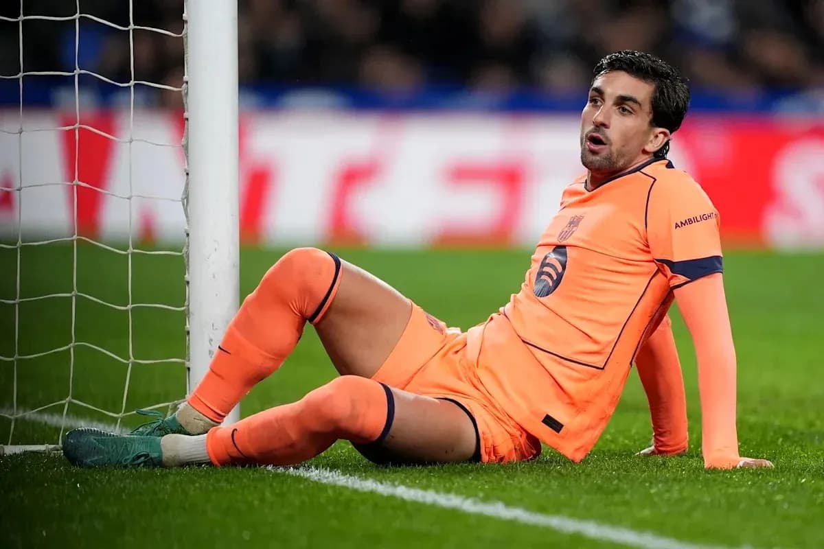 Goalkeeper sitting on pitch near goalpost Goalkeeper sitting on pitch near goalpost