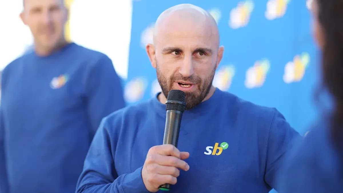 Man speaking into microphone at event Man speaking into microphone at event