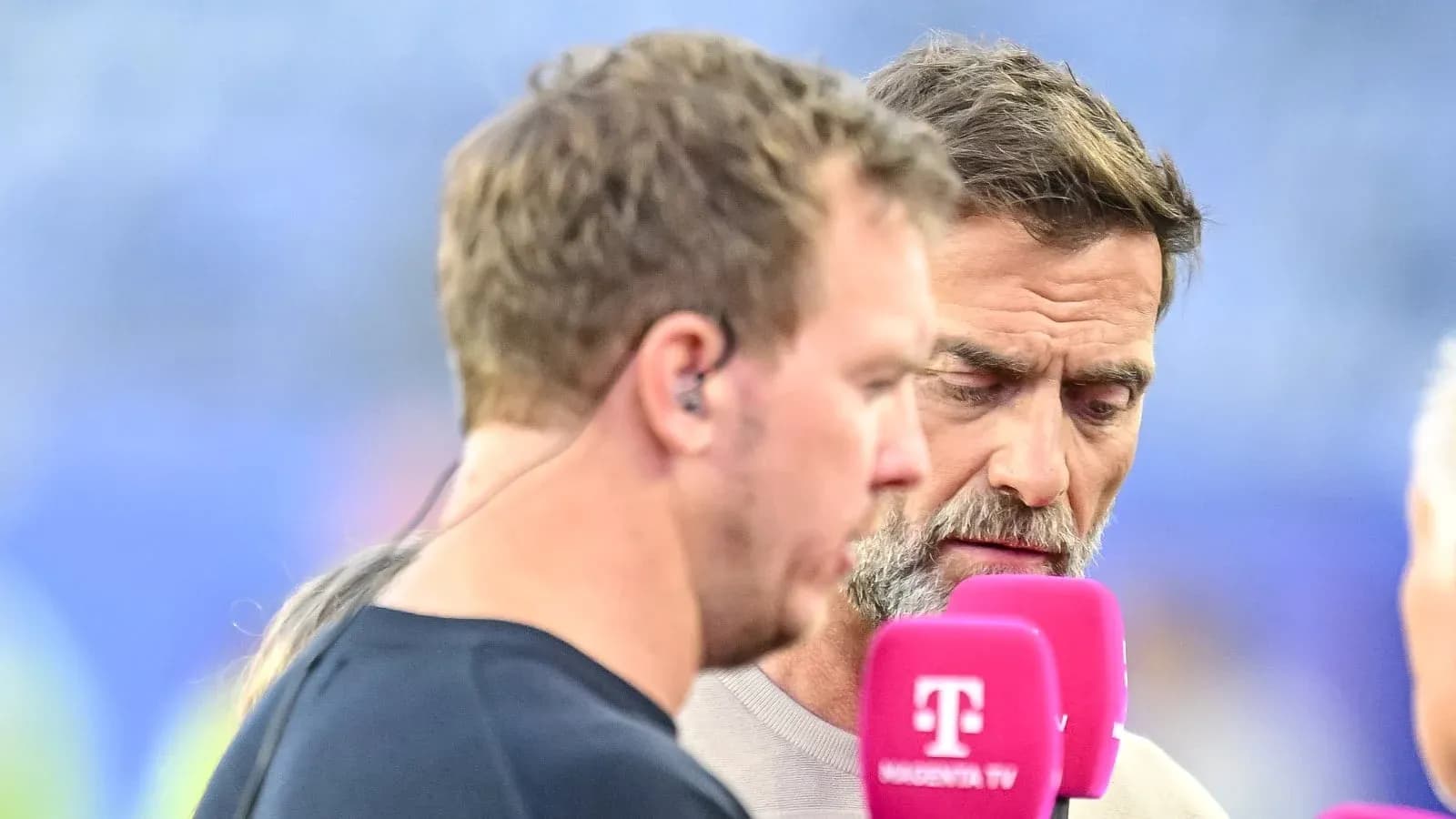 Two men speaking into microphones during interview Two men speaking into microphones during interview
