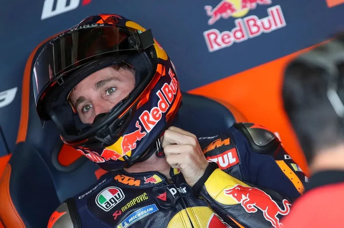 Rider adjusting helmet in Red Bull KTM garage Rider adjusting helmet in Red Bull KTM garage