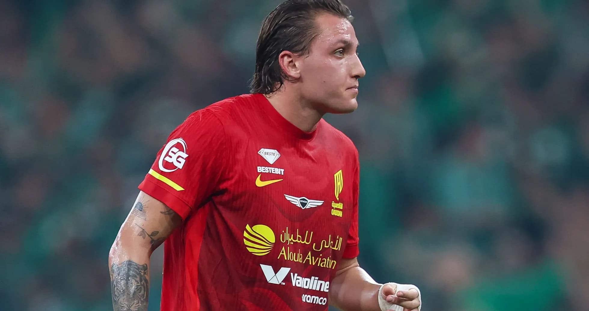 Futbolchi qizil forma kiygan, maydonda harakatda Futbolchi qizil forma kiygan, maydonda harakatda