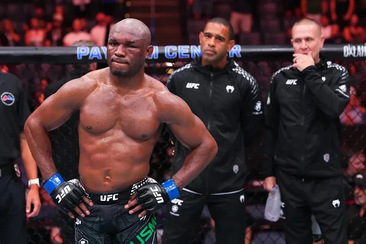 MMA fighter in the octagon with coaches behind MMA fighter in the octagon with coaches behind