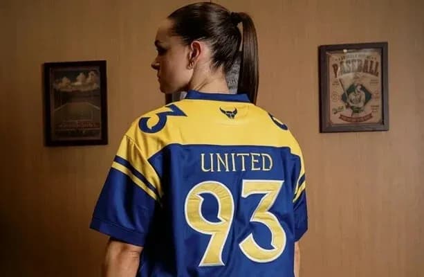 Player wearing blue and yellow jersey with '93' and 'UNITED' Player wearing blue and yellow jersey with '93' and 'UNITED'