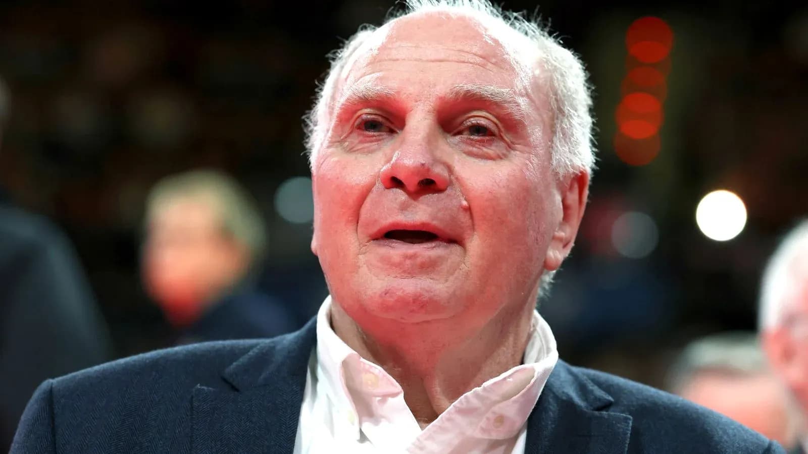 Older man in a suit at a sports event Older man in a suit at a sports event