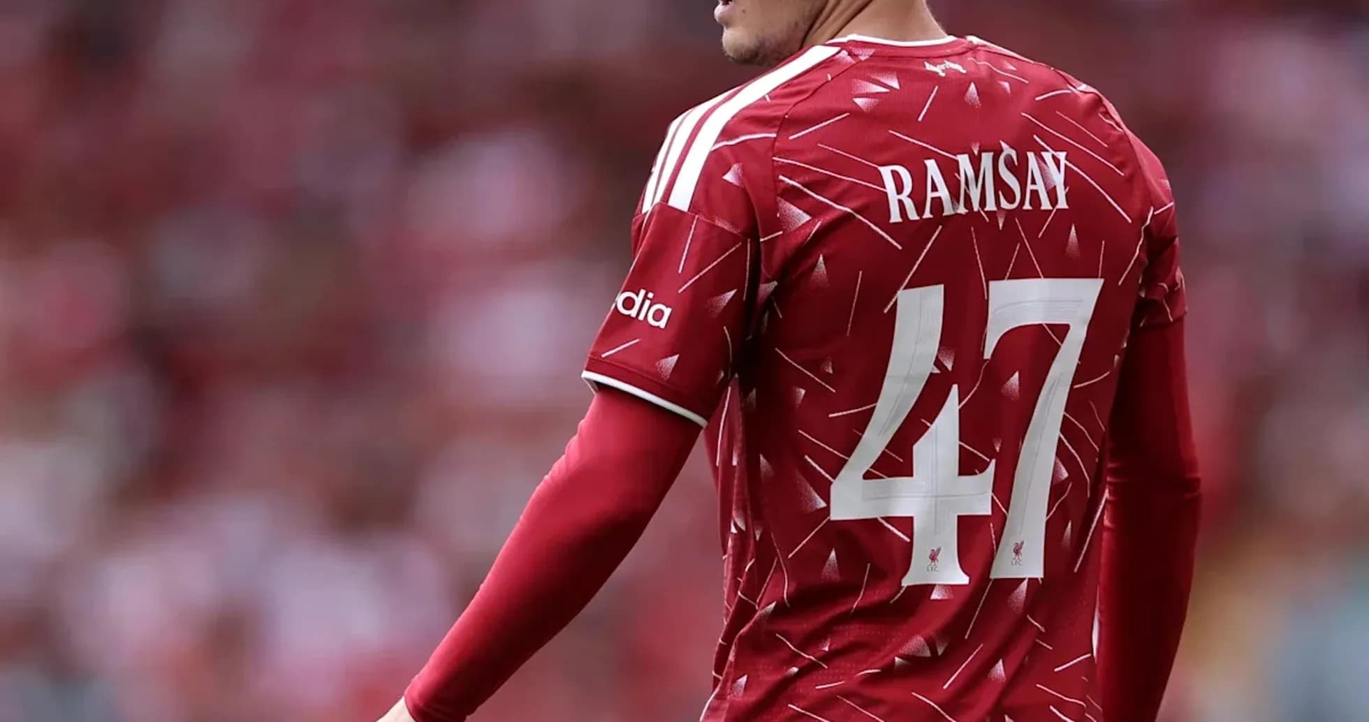 Futbolchi Ramsay qizil formada maydonda turibdi Futbolchi Ramsay qizil formada maydonda turibdi