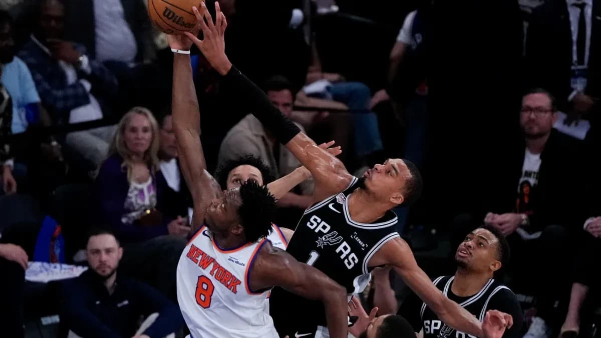 New York player attempting a shot against San Antonio defense New York player attempting a shot against San Antonio defense