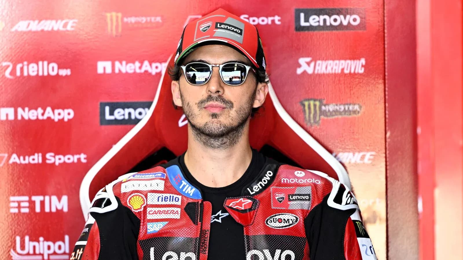 Rider in sunglasses sitting in team pit area Rider in sunglasses sitting in team pit area