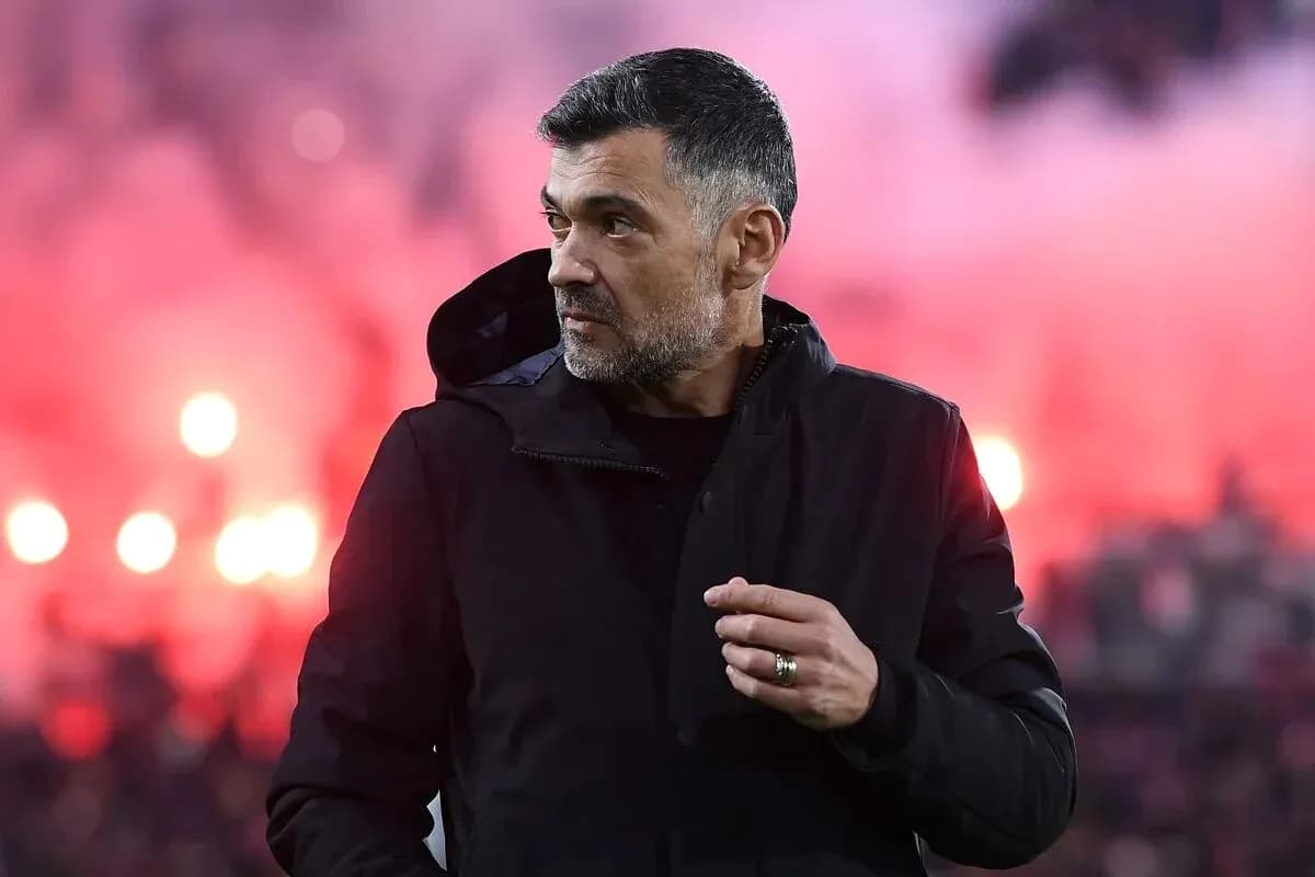 Coach observing match with flares in background Coach observing match with flares in background